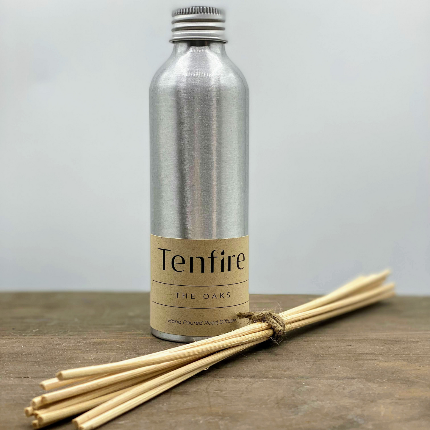 silver metal bottle reed diffuser with bamboo reeds tied next to it